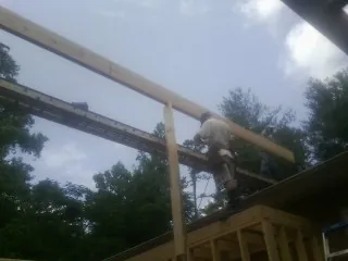 Carpenter setting a ridge beam over a new addition frame — Ice Dam Removal by Roofing Brothers in Lake Villa