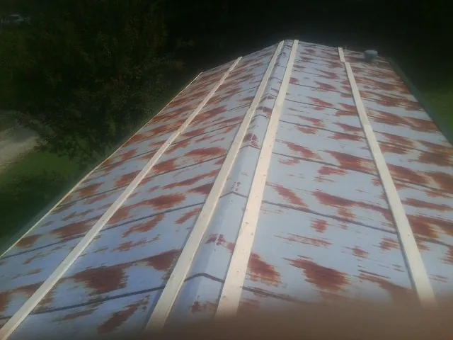 Rusted metal roof panels with new wood purlins before replacement — Storm Damage Roof Repair in Lake Villa by Roofing Brothers