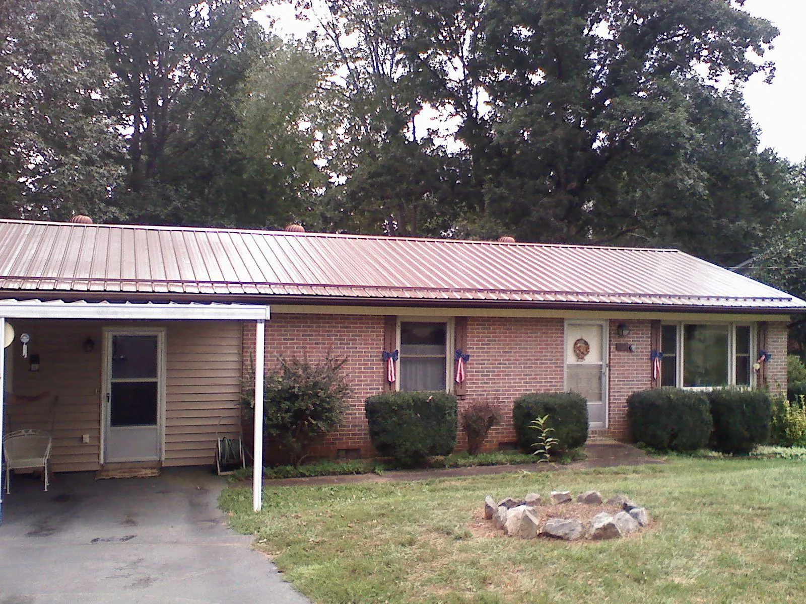 Bronze metal roof and carport on a brick ranch home — Roof Repair work by our crew in Lake Villa